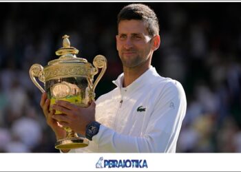 Serbia's Novak Djokovic holds the trophy as he celebrates after beating Australia's Nick Kyrgios to win the final of the men's singles on day fourteen of the Wimbledon tennis championships in London, Sunday, July 10, 2022. (AP Photo/Alastair Grant)